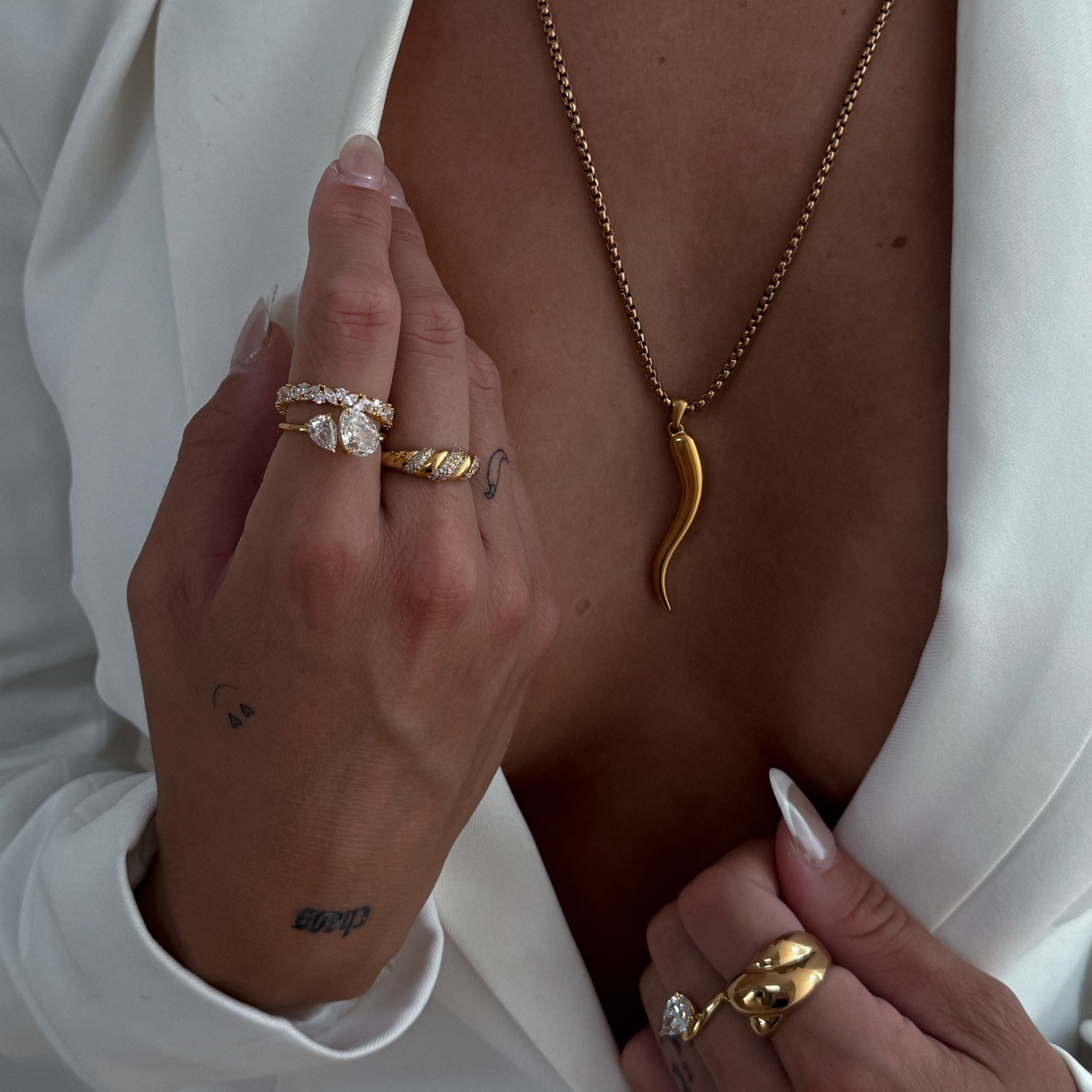 A gold-colored 925 sterling silver ring with intricate engravings and multishaped cubic zirconium stones around the entire band.
